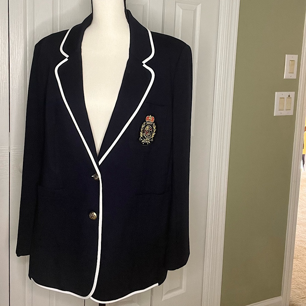 Navy blue knit blazer with white piping trim around collar.